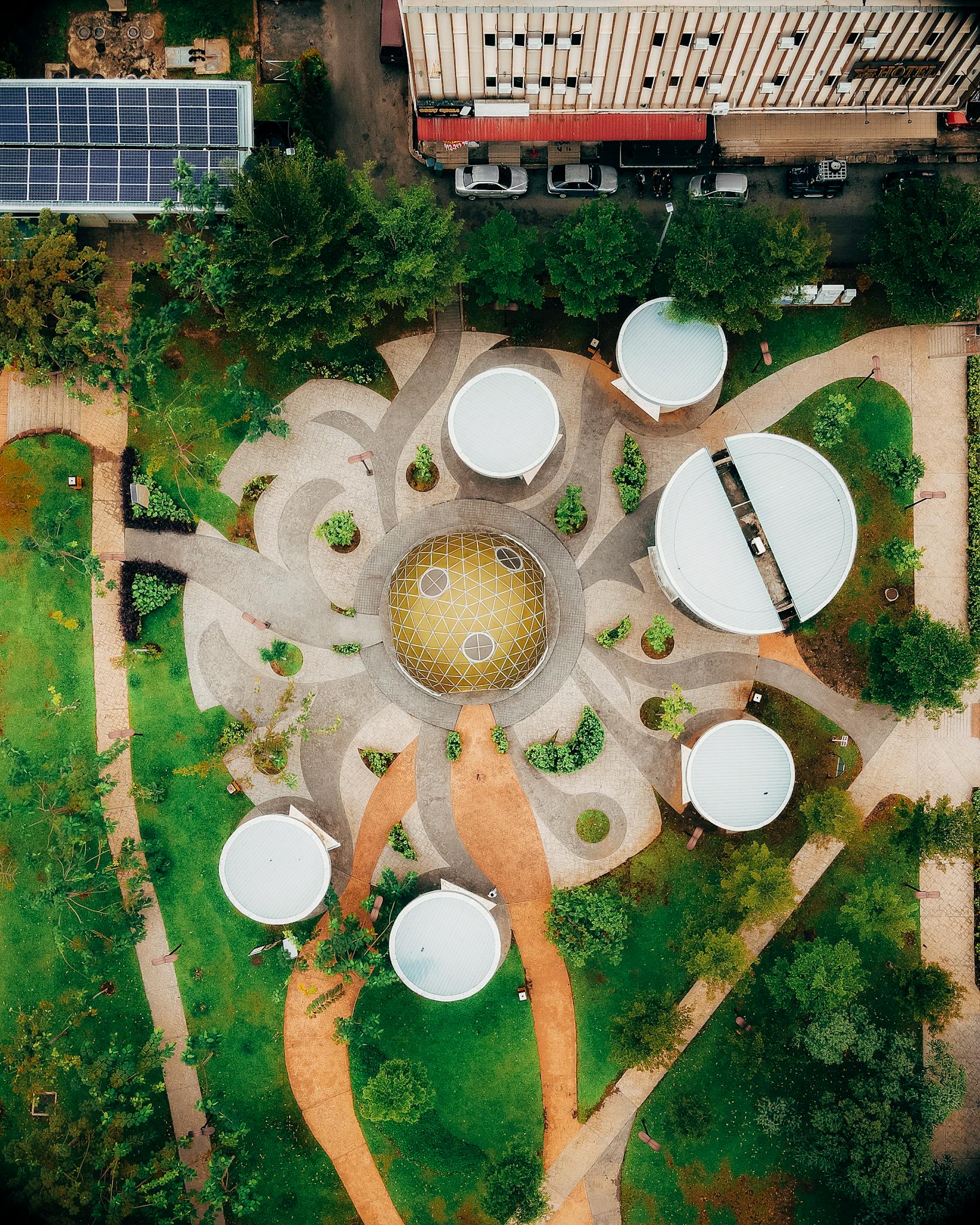 Aerial shot of a modern, futuristic garden with geometric pathways and circular structures.