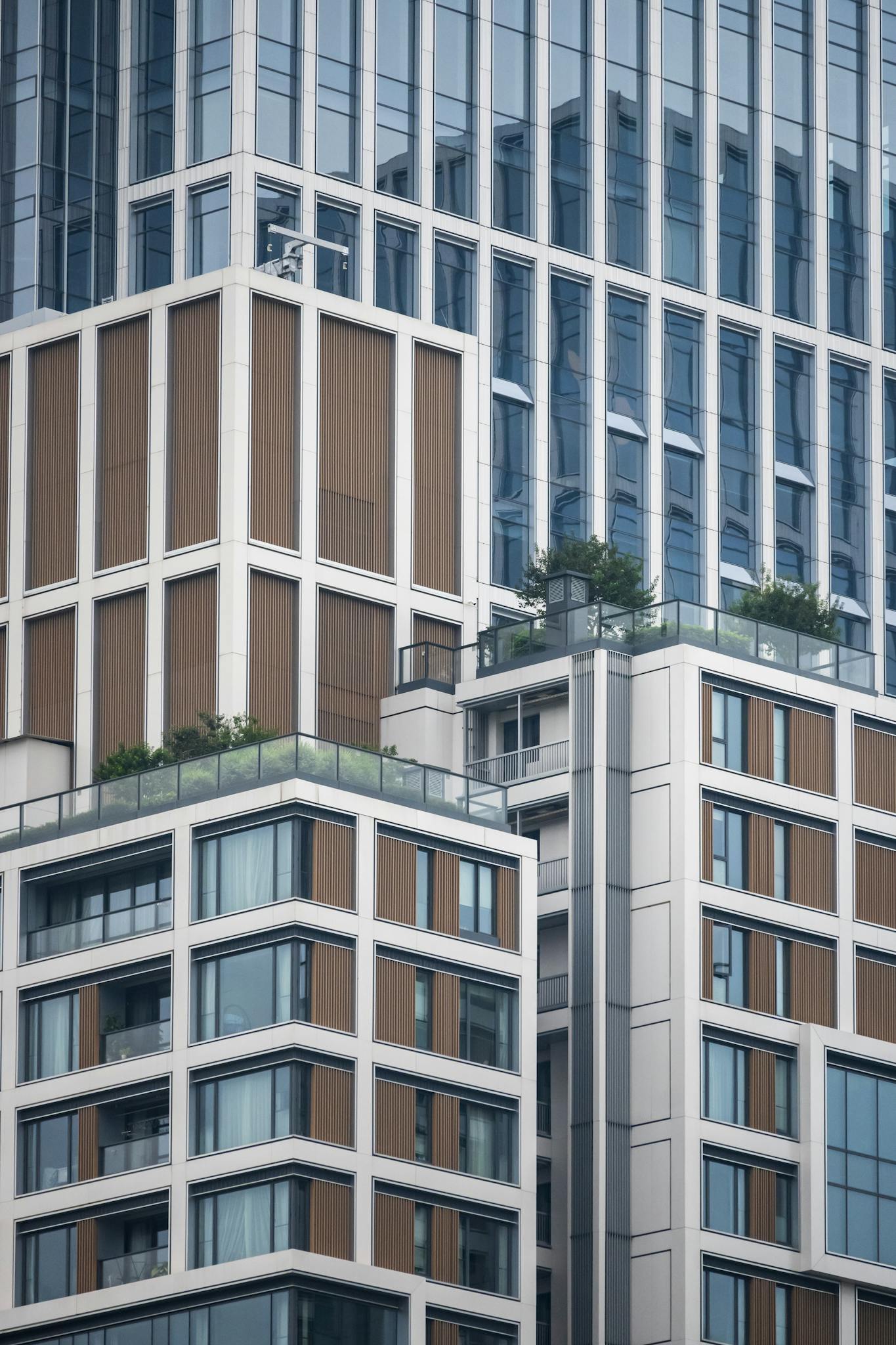 Close-up of a modern high-rise building with rooftop gardens, showcasing urban architecture.